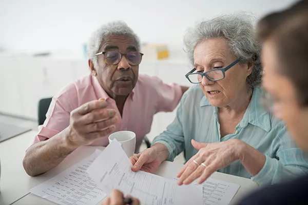 An elderly couple discusses paperwork.