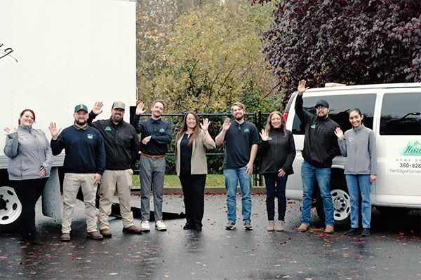 Heritage Home Revival employees stand together outside waving and smiling.
